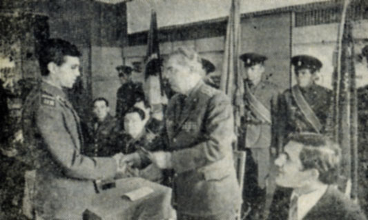 Офицер К. П. Ильин вручает комсомольский билет отличнику боевой и политической подготовки младшему сержанту М. Лазареву