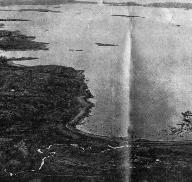 Аэрофото норманнского поселения в Ланс-о-Мидоузе на крайнем севере Ньюфаундленда. Автор открыл его в 1960 г.; четыре года продолжались археологические раскопки. Важнейшие раскопы накрыты павильонами. Самый большой раскоп - крайний справа, за рекой в павильоне находятся остатки кузницы. Равнина и рыбачий поселок расположены правее, их не видно на снимке