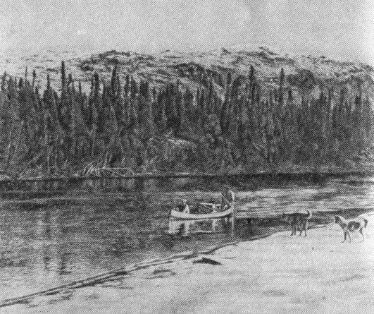 Индейцы наскапи идут на каноэ вверх по реке, к охотничьим угодьям. Собаки следуют за хозяевами вдоль берега. Поздняя осень