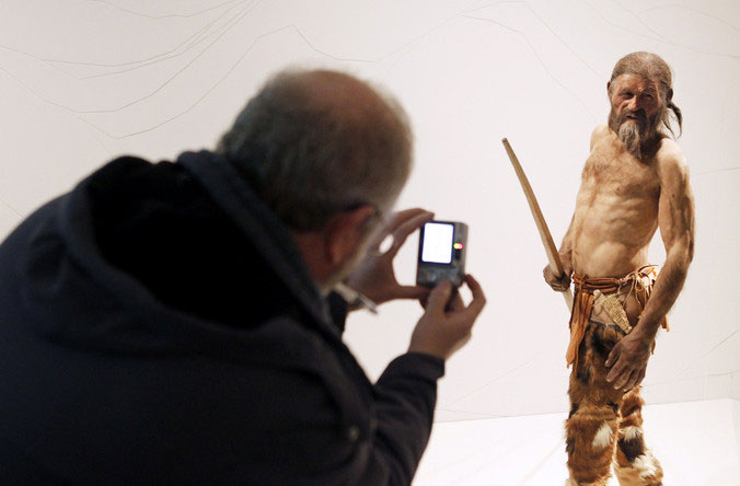 Мужчина фотографирует 3D модель тирольской мумии